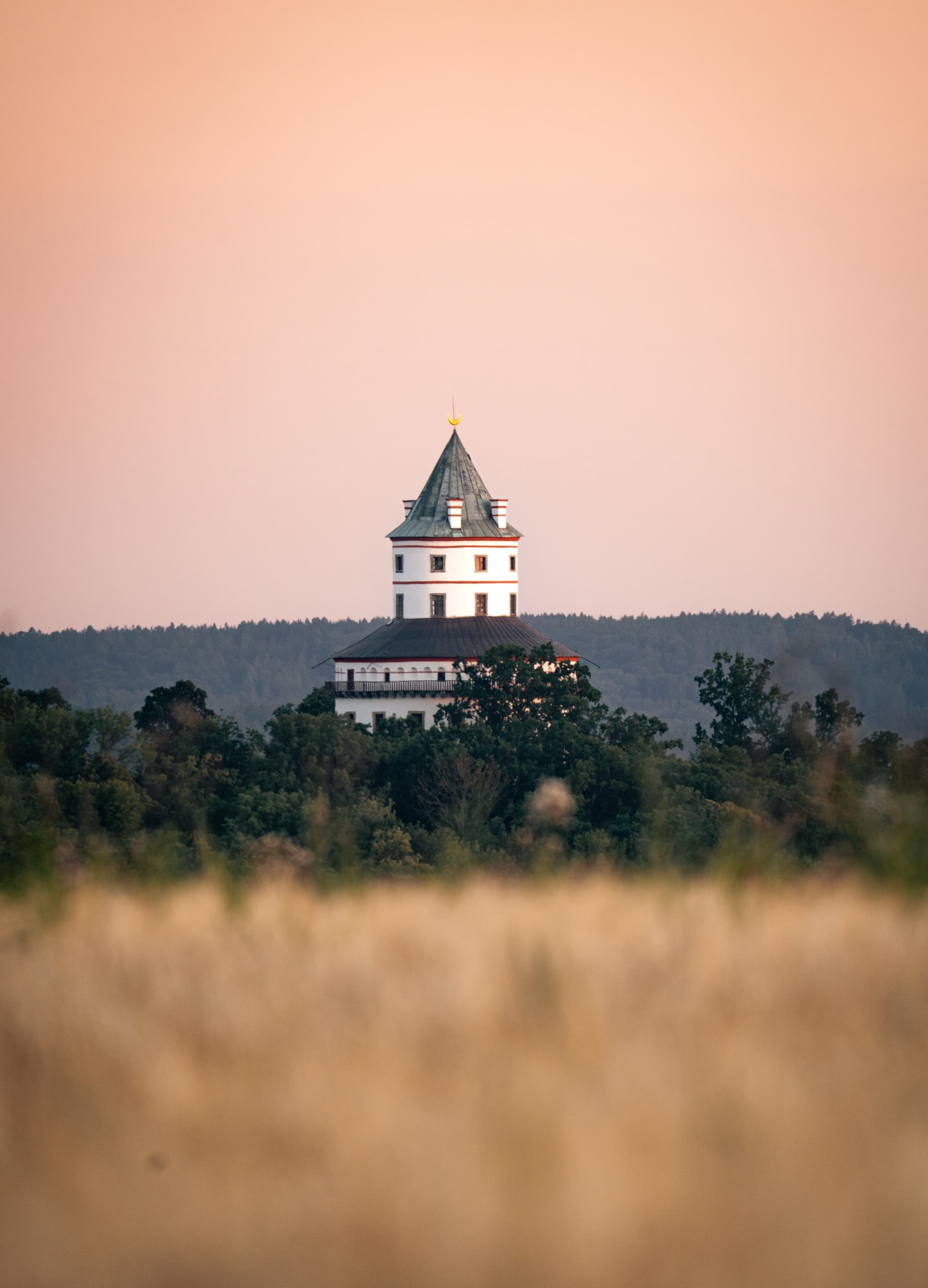 Zámek Humprecht za soumraku nad obilným polem